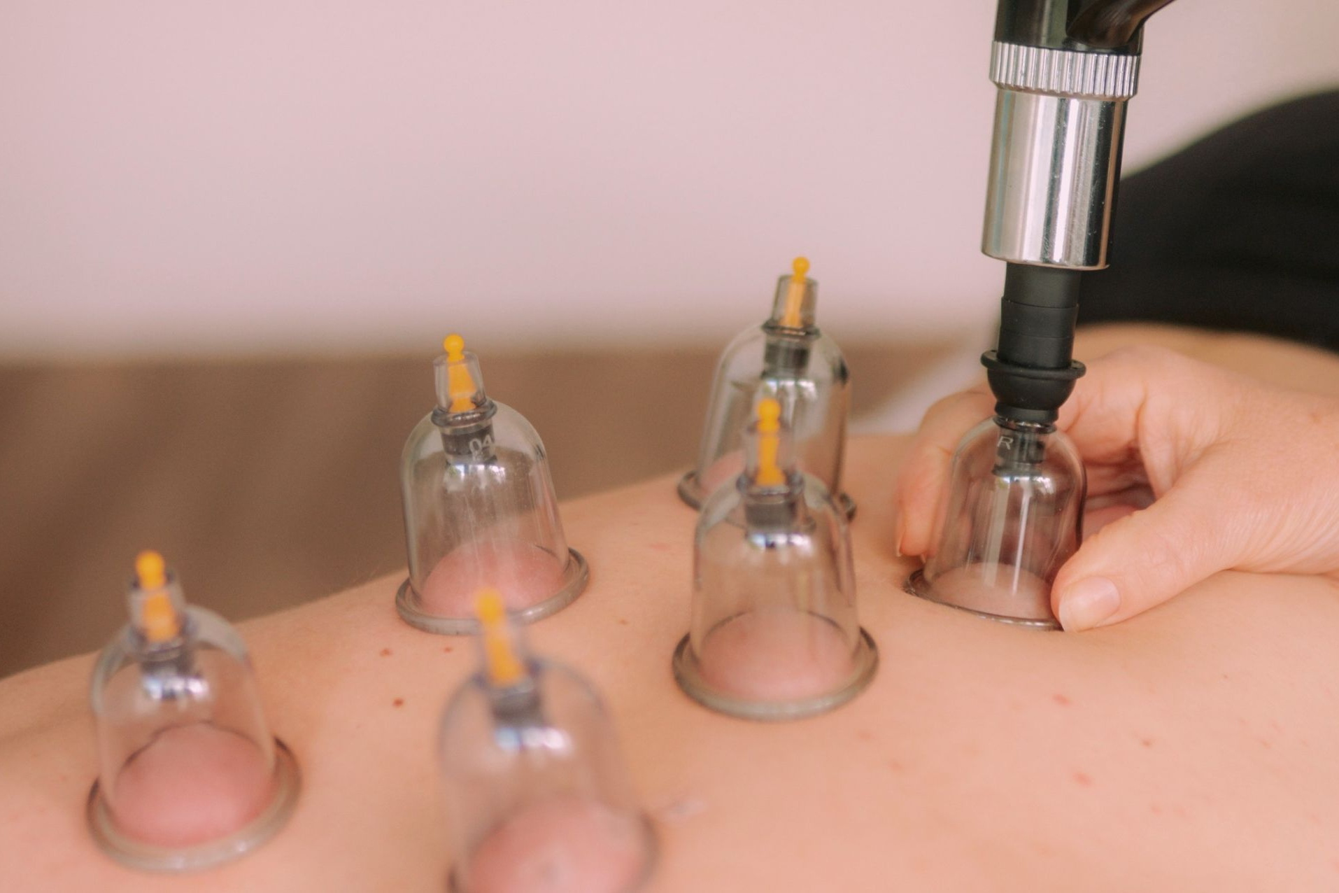 Hände beim Drücken eines Spenders mit Massage-Lotion