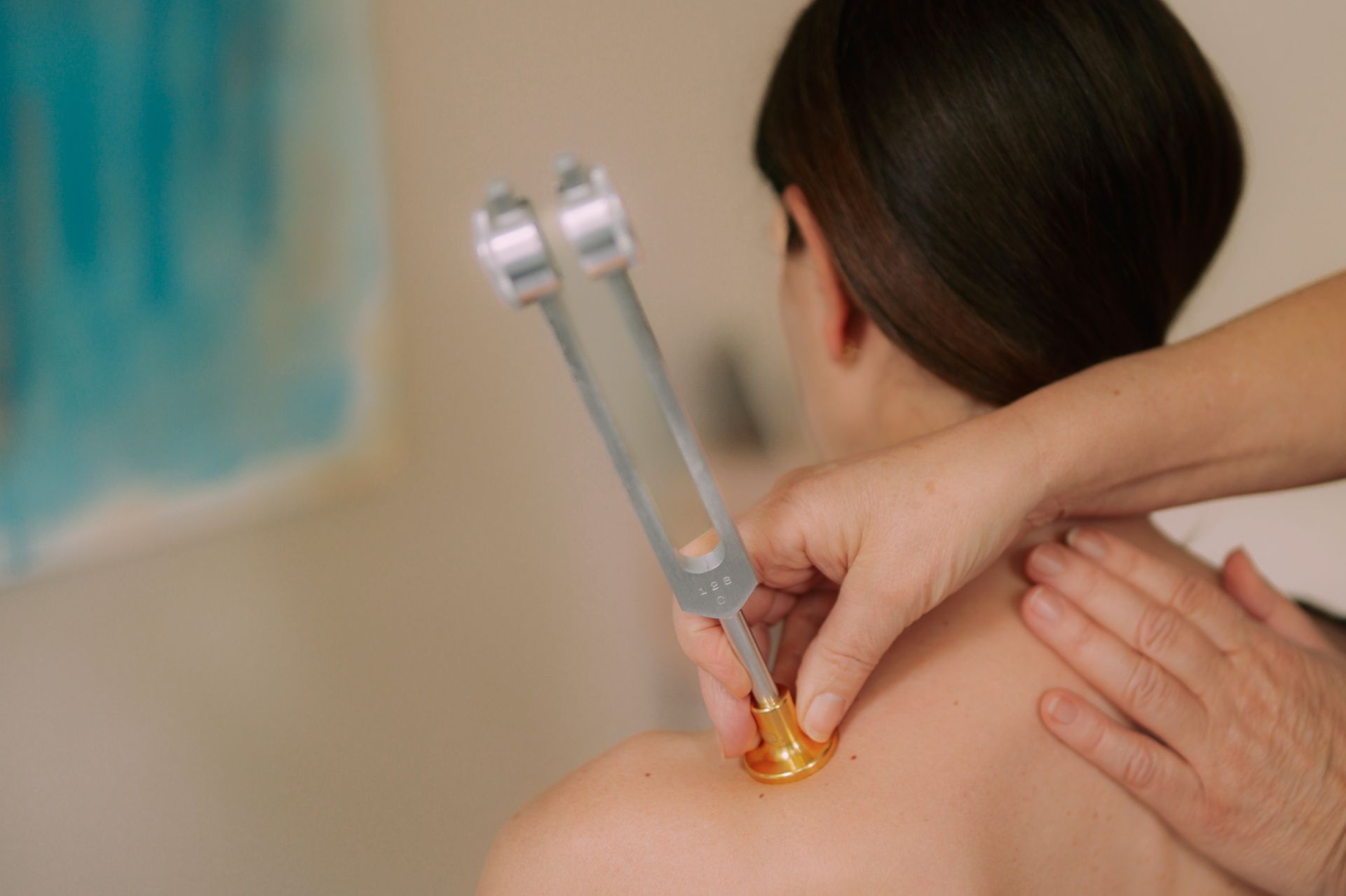 Physio Winterkorn Behandlung Kinesiotape Kinesiotaping mit grünem und rotem Tape an Oberarm eines Patienten