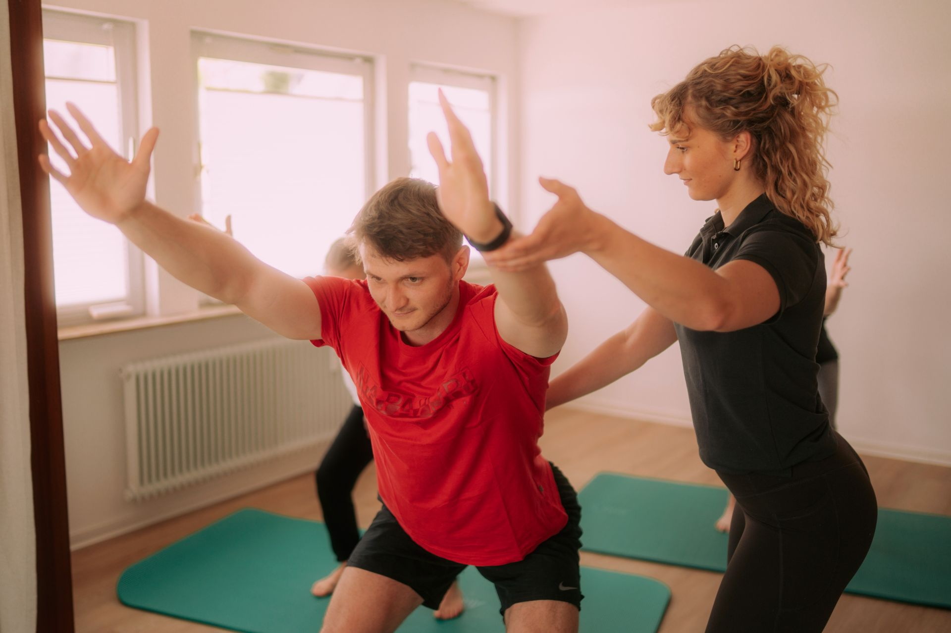 Patientin bei krankengymnastischen Übung mit Ball auf Trampolin